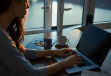 woman sitting beside table using laptop