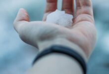 person holding white snow on hand