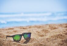 wayfarer sunglasses on beach sand during daytime