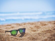 wayfarer sunglasses on beach sand during daytime