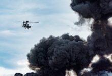 black helicopter beside black smoke