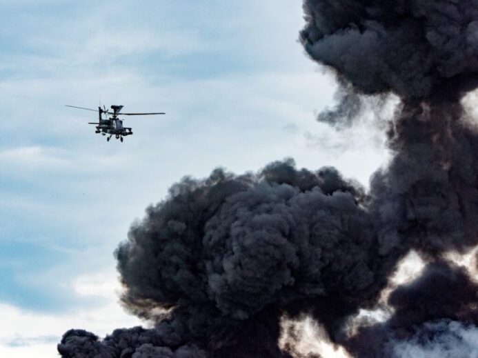 black helicopter beside black smoke