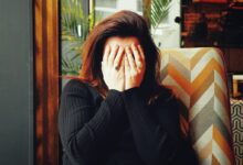 woman in black long sleeve shirt covering her face