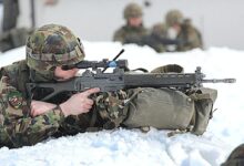 man in green and brown camouflage army suit holding rifle