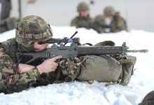 man in green and brown camouflage army suit holding rifle