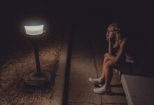 woman in black tank top sitting on concrete floor