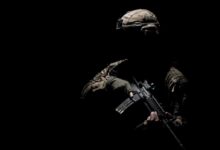 man in black helmet holding rifle