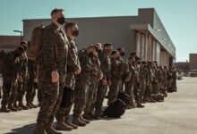 men in black and brown camouflage uniform standing on brown floor