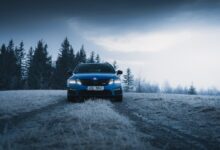 blue car on snow covered field during daytime