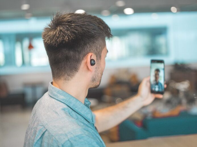 shallow focus photo of man in gray collared top taking selfie
