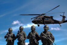 Four Soldiers Carrying Rifles Near Helicopter Under Blue Sky