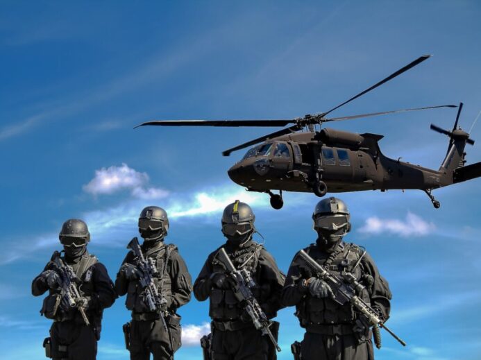 Four Soldiers Carrying Rifles Near Helicopter Under Blue Sky