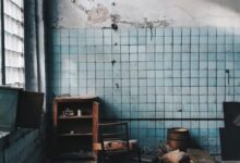 Old house with damaged furniture near weathered wall