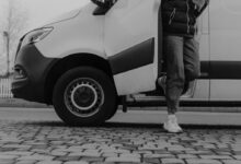 Grayscale Photo of a Man Getting Out of the Vehicle
