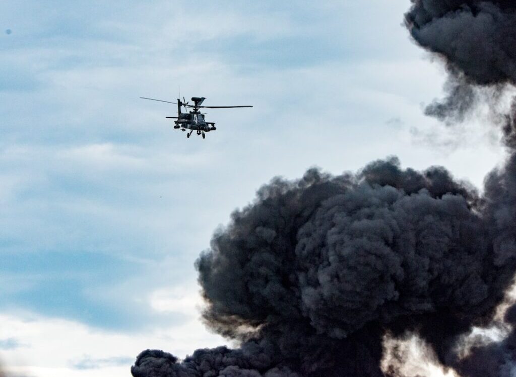 black helicopter beside black smoke