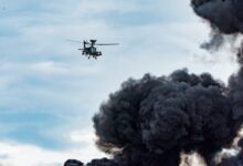 black helicopter beside black smoke