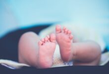shallow focus photography of baby wearing white diaper lying
