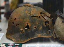 rusty soldier helmet with holes on white surface