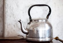 stainless steel kettle on brown wooden table