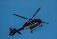 red and white helicopter flying in the sky
