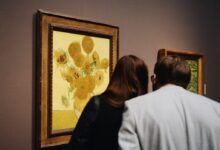 man and woman standing near sunflower painting