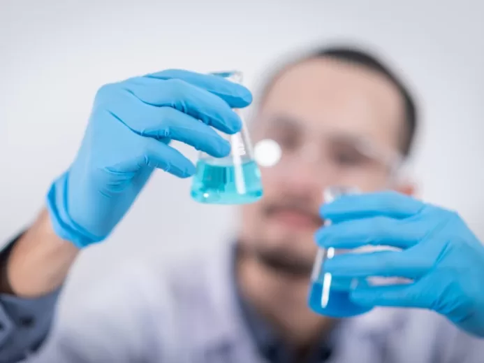 Person Holding Glass Flasks