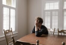 Photo of Man Leaning on Wooden Table