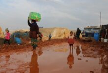Ethnic children and adults refugees walking on dirty ground