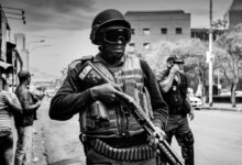 grayscale photo of soldier carrying pump-action rifle