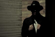 man wearing black fedora hat and black suit jacket