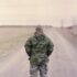 man in green camouflage uniform standing on road during daytime