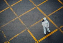 man in white thobe walking on grey and yellow concrete pavement