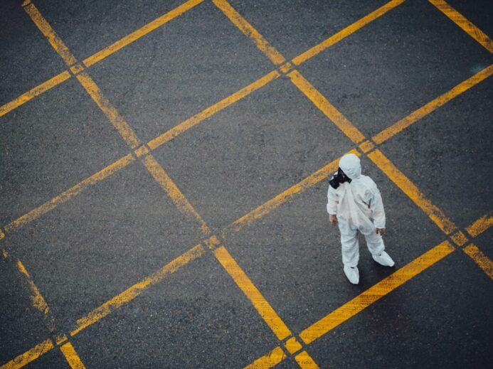 man in white thobe walking on grey and yellow concrete pavement
