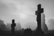 silhouette of cross under cloudy sky during daytime