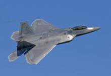 flying gray jet plane