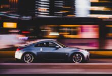 panning photography of gray coupe on road