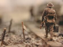 soldier walking on wooden pathway surrounded with barbwire selective focus photography