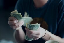 focus photography of person counting dollar banknotes