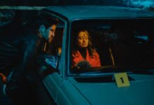 woman in black leather jacket sitting on car