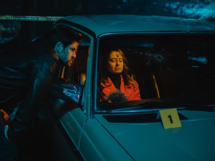 woman in black leather jacket sitting on car