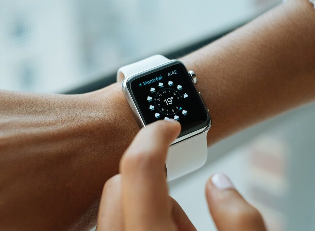person wearing silver aluminium case Apple Watch with white Sports Band