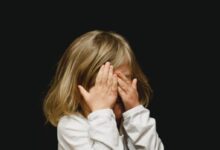 girl covering her face with both hands