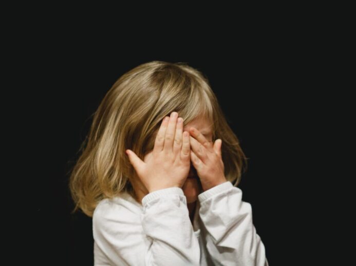 girl covering her face with both hands