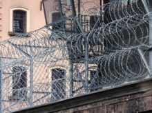 gray barbwire on fence near building during day