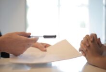 Crop businessman giving contract to woman to sign