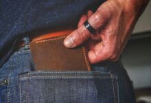 person holding black and brown leather bag