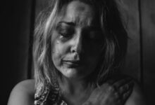 grayscale photo of woman crying holding her right chest