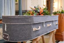a large gray suitcase sitting on top of a wooden stand