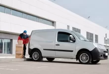 Delivery Man With Boxes next to a White Van