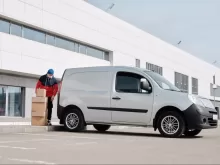 Delivery Man With Boxes next to a White Van
